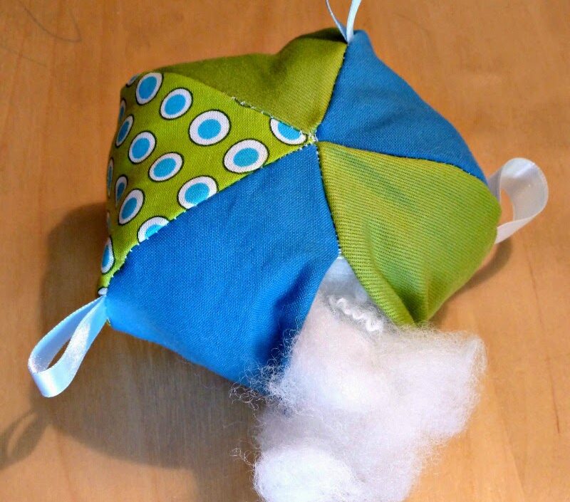 stuffed baby soft ball toy in green and blue with large dots and taggie 