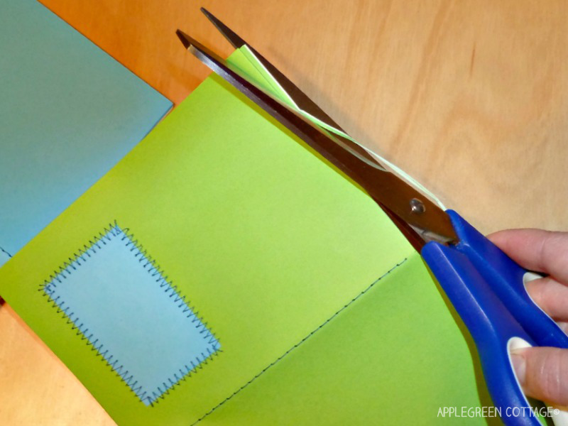 a semi-finished paper notebook being trimmed by scissors to fit 