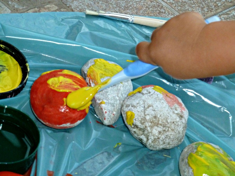 kids hand performing rock painting crafts