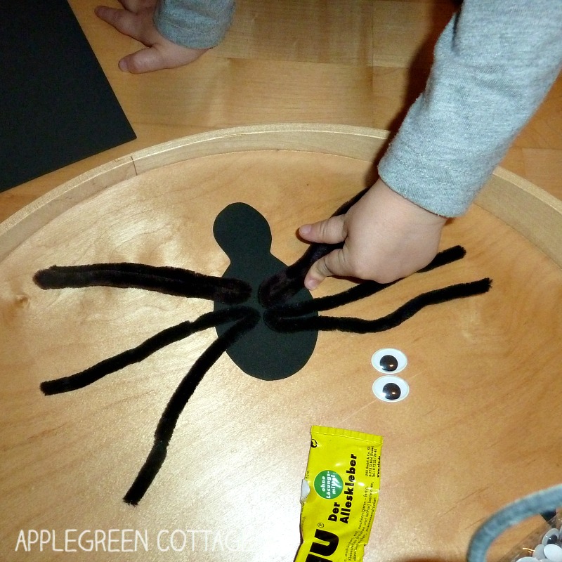 child's hand pressing the craft foam spider pieces together