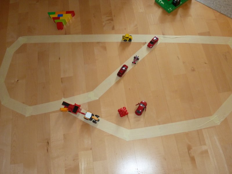 masking tape on the floor with tiny toy cars