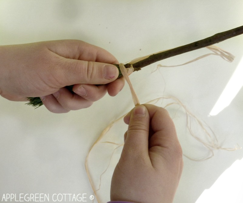 hands making a diy paint brush