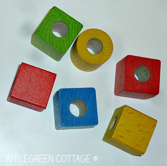 wooden blocks with holes drilled in them for a staching toy set