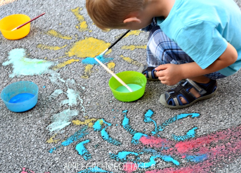 a child painting on the sidewalk