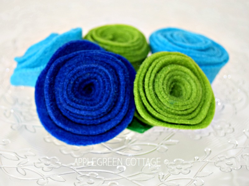 finished rolled felt flowers in blue, green and aqua