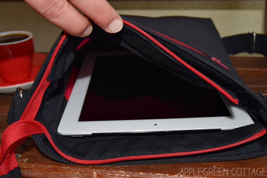 hand holding an ipad bag open with ipad visible in the bag