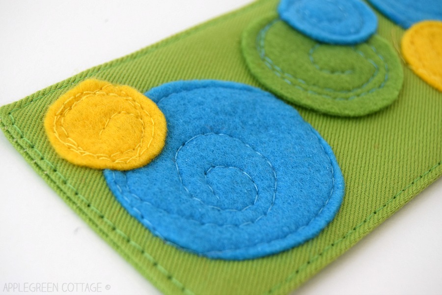 blue and yellow felt circles appliqued on fabric with a sewing machine