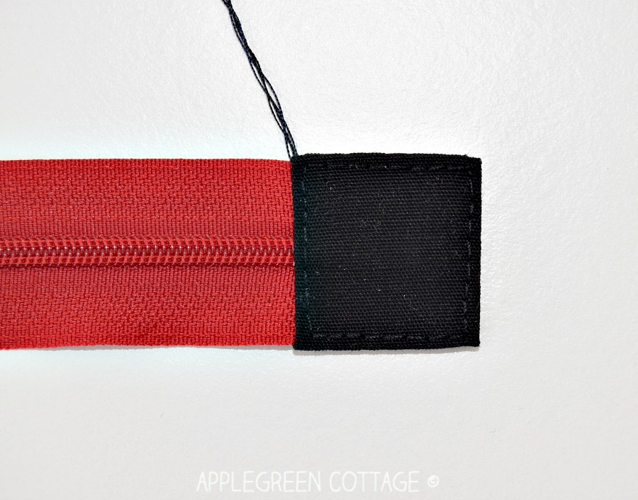 zipper tab sewn to one end of a zipper