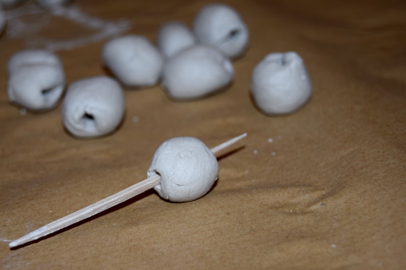 white air dry clay beads drying on a beige surface