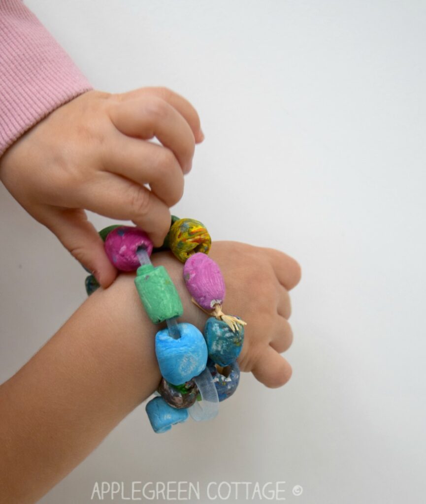 two painted diy bracelets made with air dry clay on a kids wrist