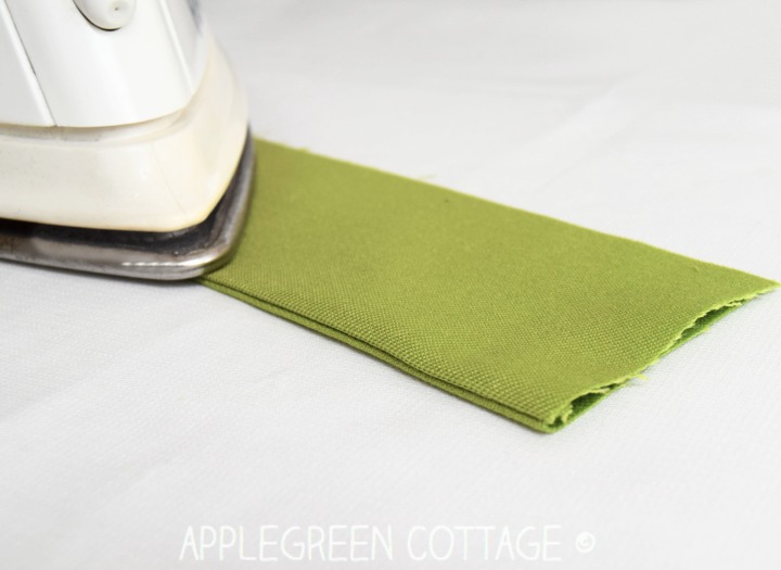 folded green fabric to finish a French seam