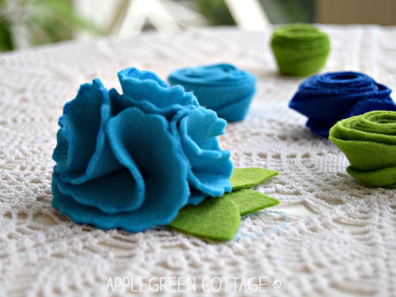 diy felt spring flowers with green leaves on a white surface