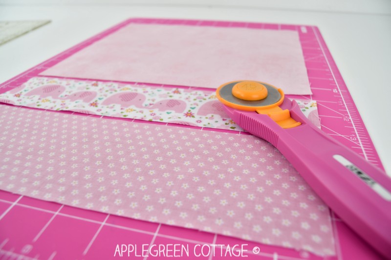 pink rotary cutter with fabric on cutting table