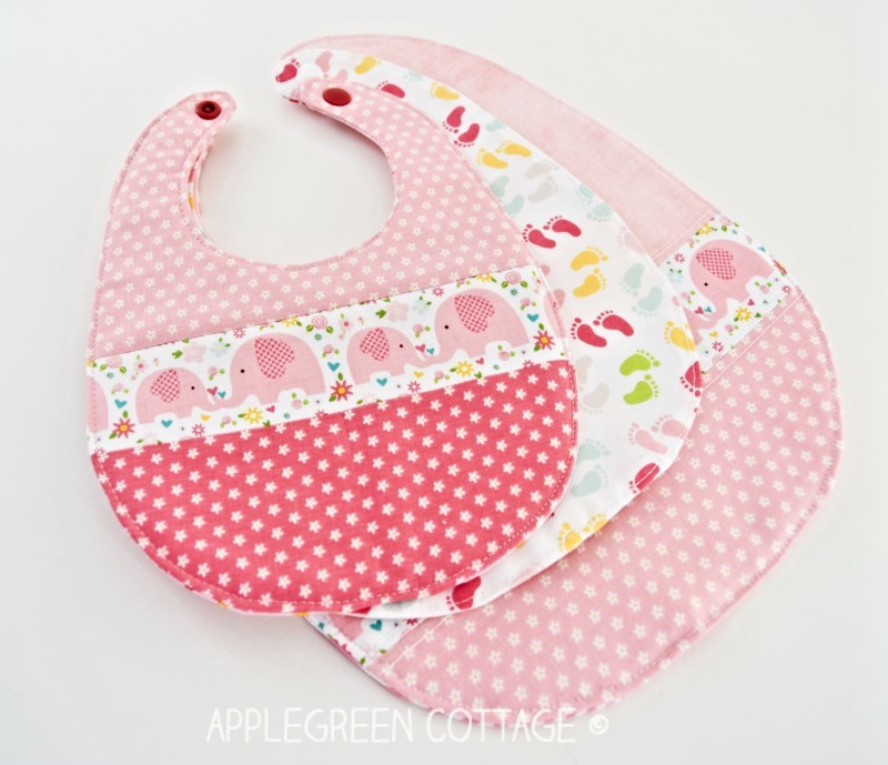 three pink bibs sewn with free baby bib pattern