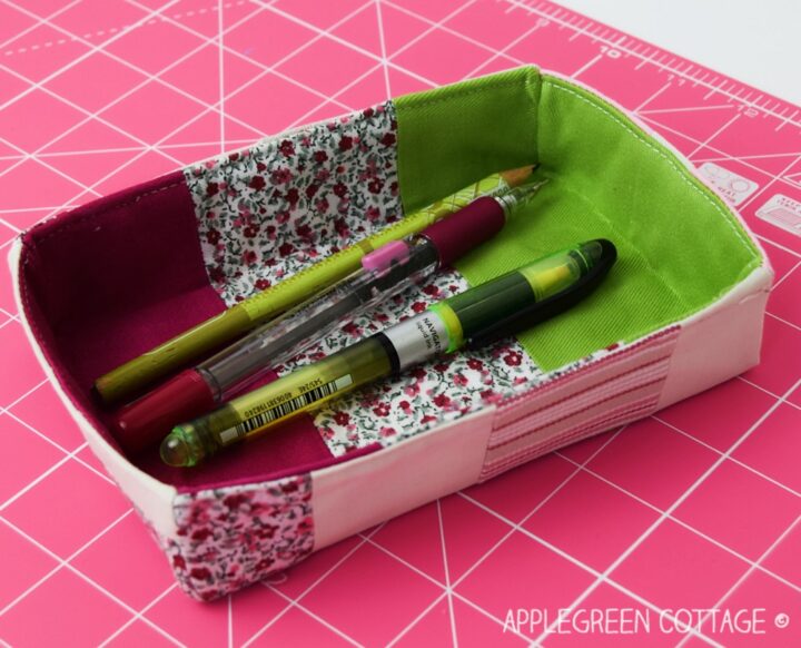 a diy fabric pencil tray holding a set of pencils and pens