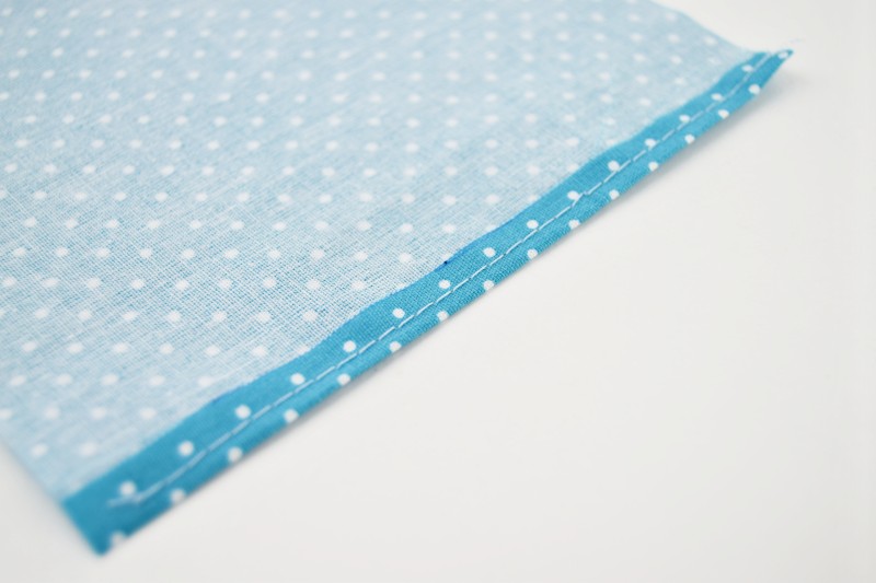 polkadot fabric placed with the wrong side up and with one raw edge folded back