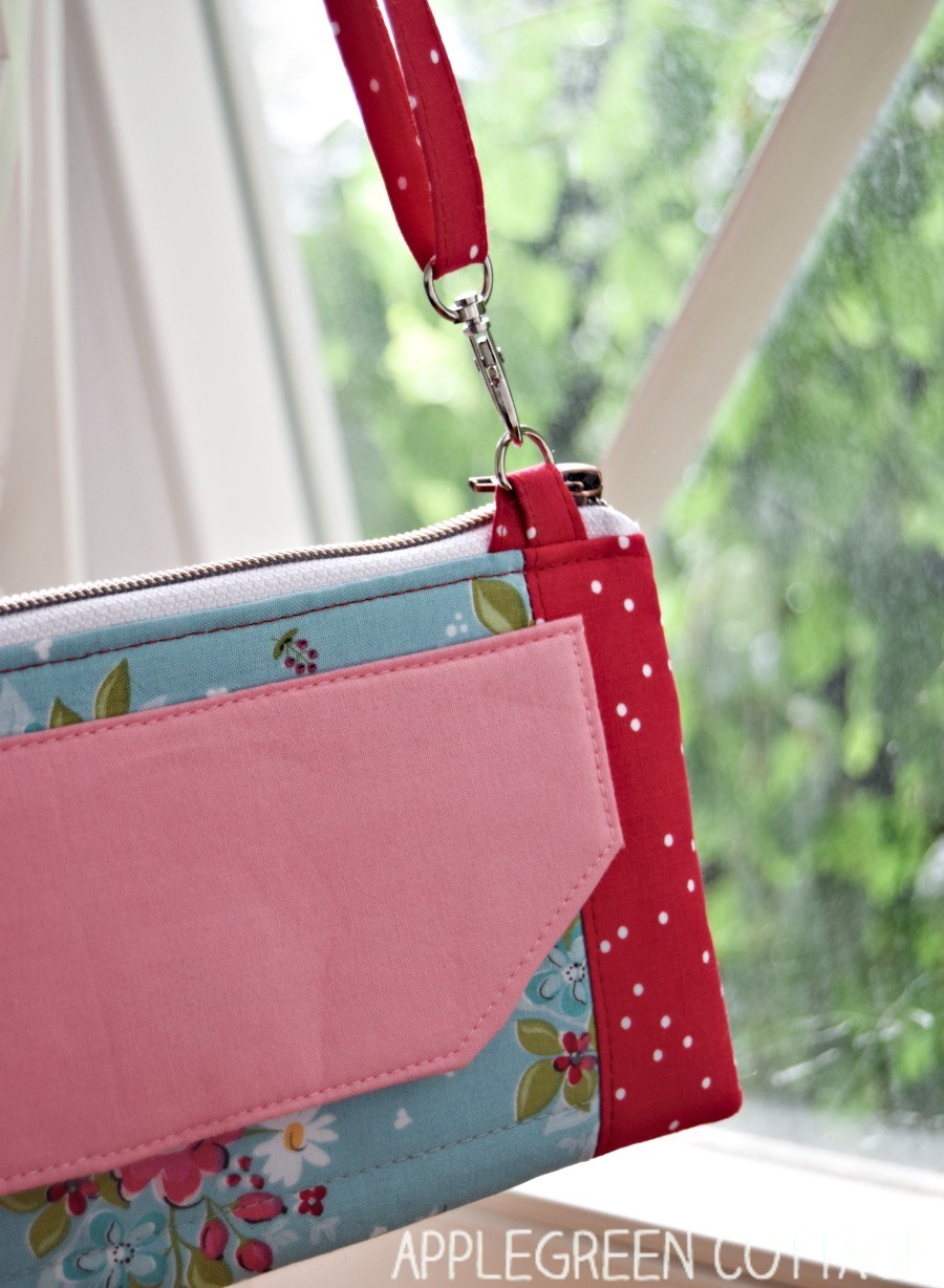 crossbody wallet bag hanging in front of a window with lots of greenery