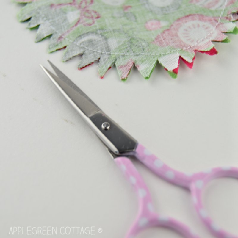 small scissors next to trimmed seam allowance of a fabric Christmas stocking 