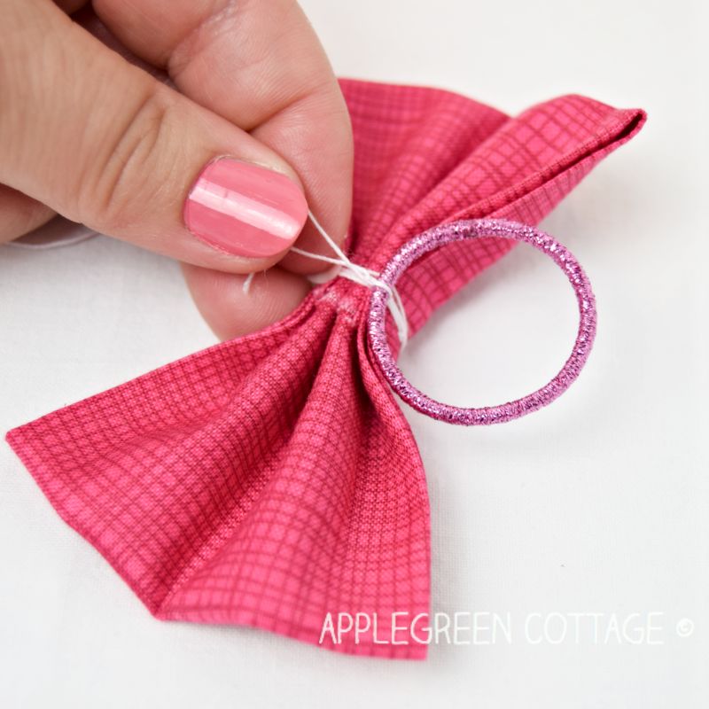 hand tying a knot on a fabric bow