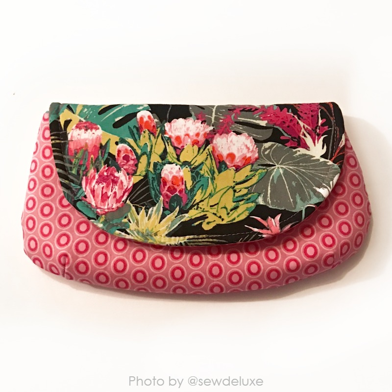 a finished fabric clutch purse with floral pattern and red circles