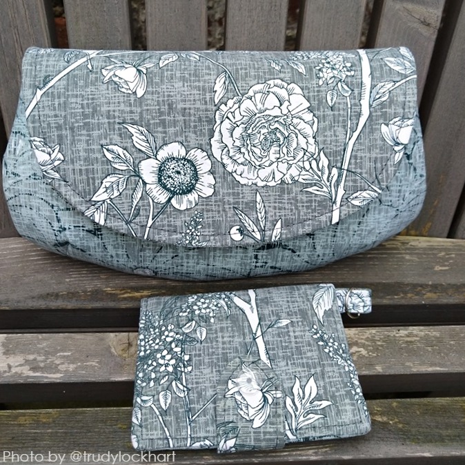 a set of handmade fabric clutch purse with floral pattern and a small wallet