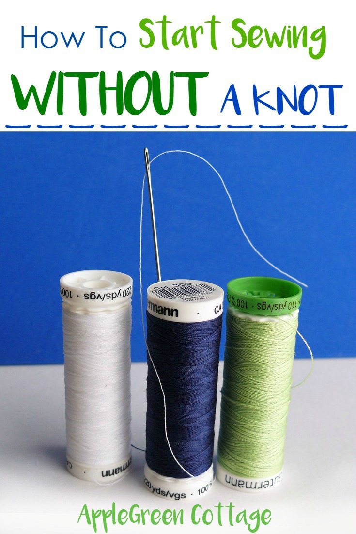 three spools of thread and a hand sewing needle