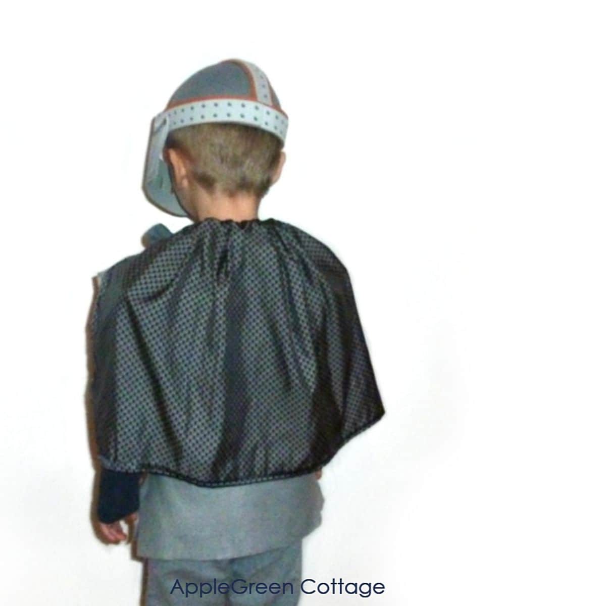 a child wearing a homemade knight cape as part of a halloween costume