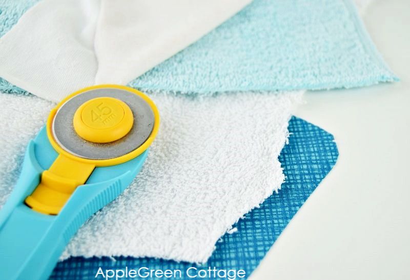 materials laid out for sewing bandana bibs, next to a rotary cutter