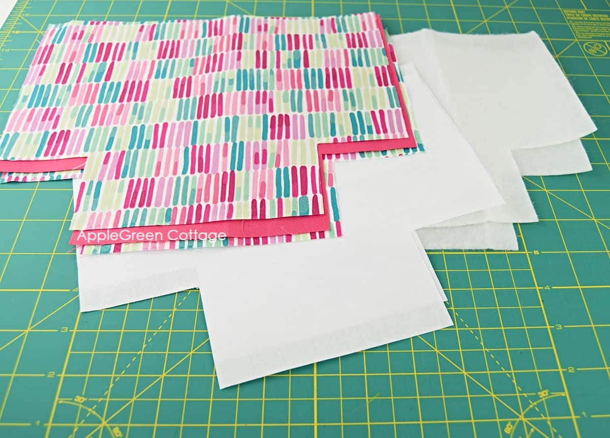 fabric pieces cut from the free basket pattern from printed cotton fabric, interfacing, and fusible fleece
