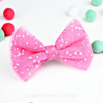 a finished glitter pink tulle bow with mint and pink and white pompoms