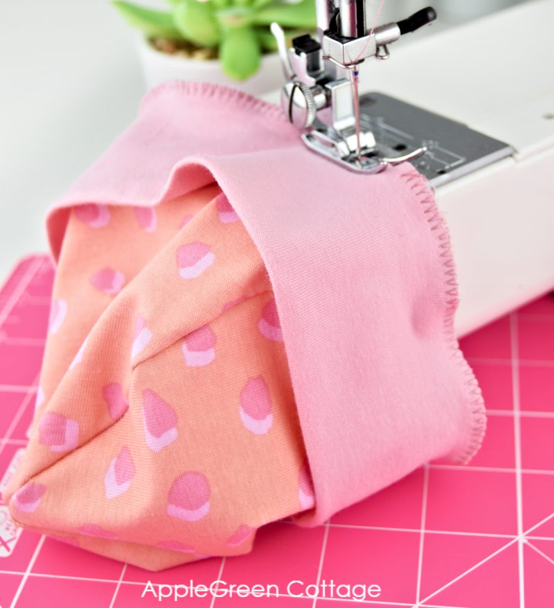 sewing machine with a semi-finished pink baby hat 