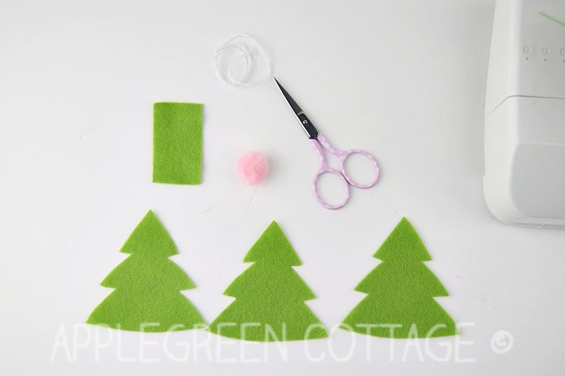 green felt pieces, thread, and notions ready to sew a christmas tree felt ornament