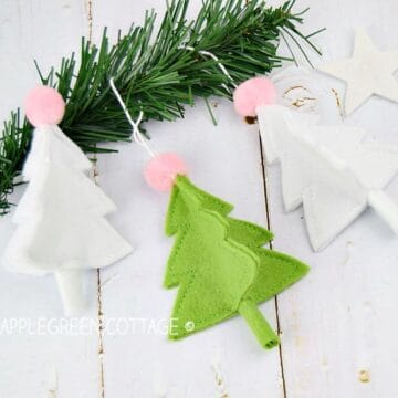 diy christmas trees made out of white and green felt and decorated on a pine tree