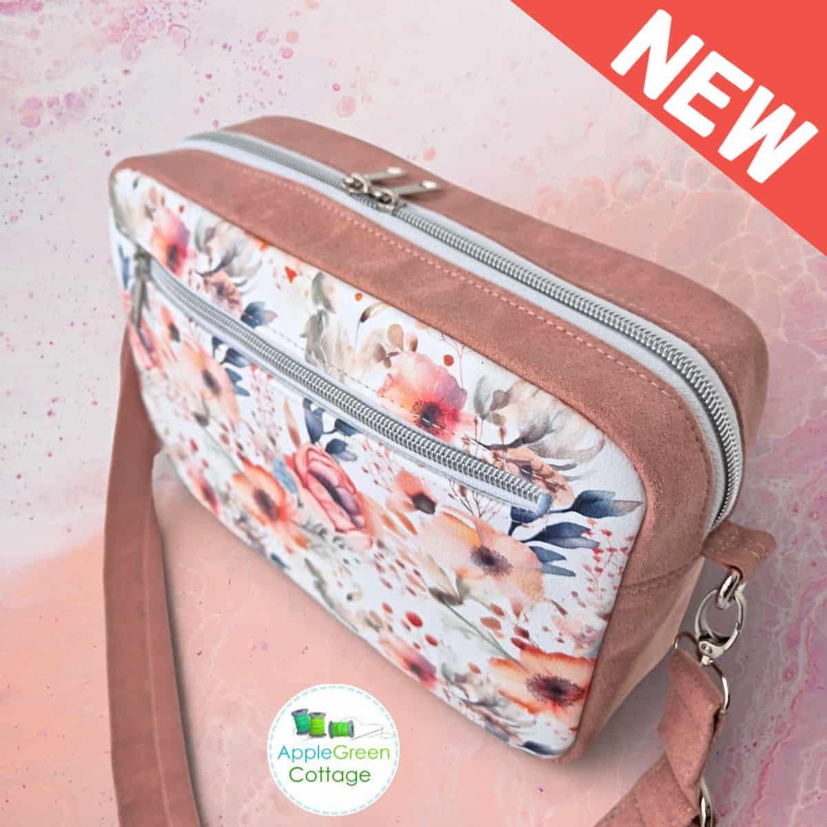 Handmade boxy crossbody bag with floral front pocket, double zipper top, and adjustable strap.