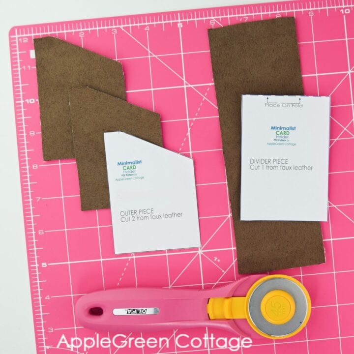 faux suede pieces cut for a front pocket wallet on a pink cutting mat 