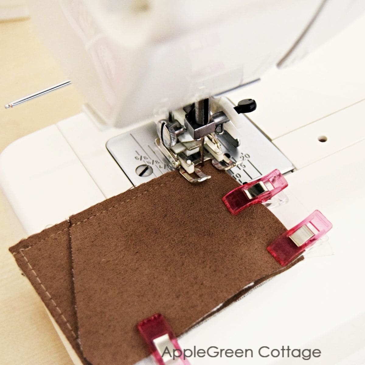 brown suede pouch being sewn using a walking foot on a sewing machine