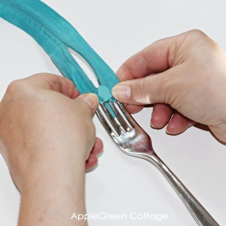 hands attaching a zipper slider to zipper tape