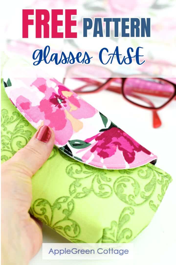 a beautiful handmade eyeglasses case with a flap and a magnetic closure, placed next to red eyeglasses and flowers