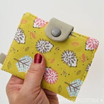 a finished yellow printed fabric wallet held in hand