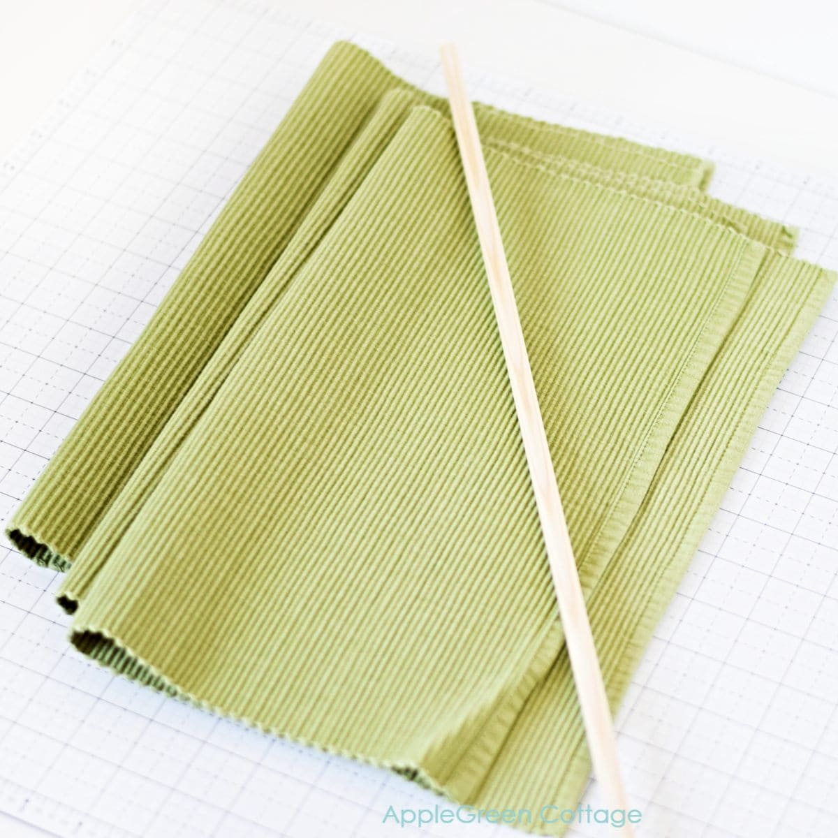 three folded placemats and a dowel rod