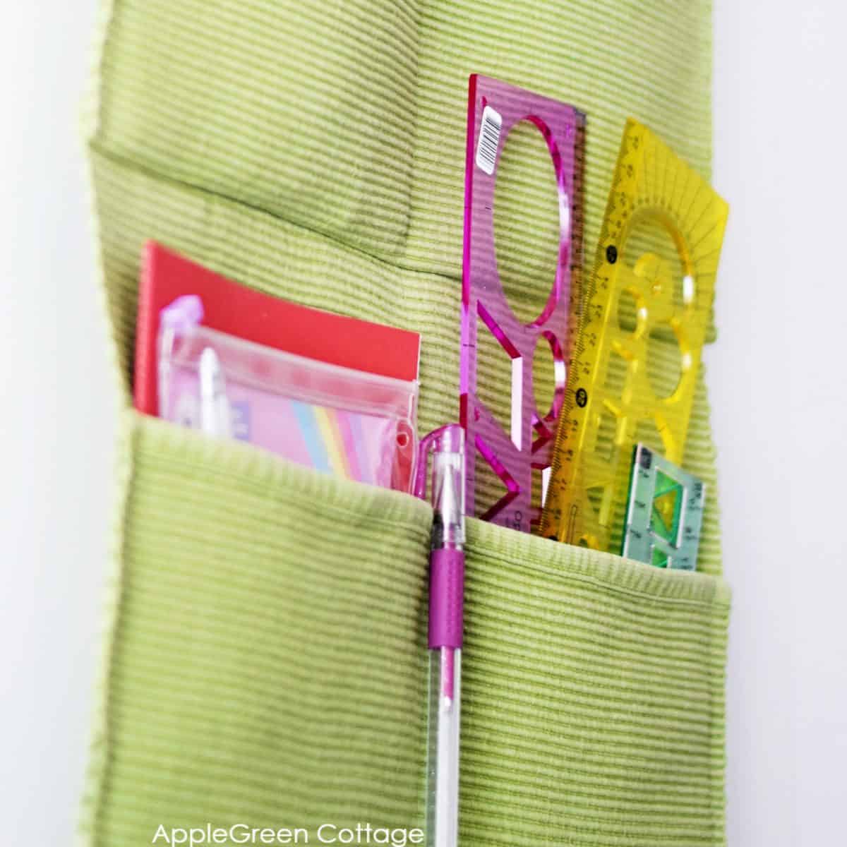 closeup of a finished diy wall organizer filled with school supplies