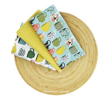 Three homemade diy cloth napkins on a bamboo plate, sewn on a home sewing machine.