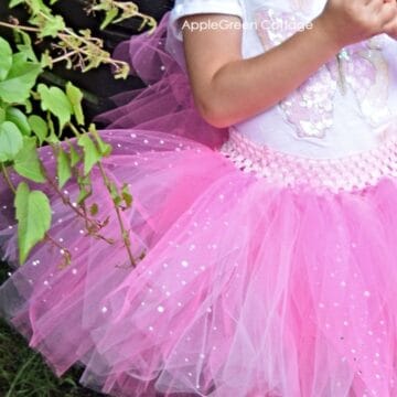 a small child wearing a handmade pink tulle tutu skirt