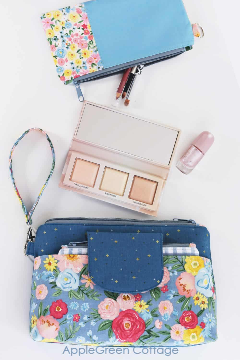 diy makeup bag in blue floral fabric and a small zippered pouch sewin with a pattern, with cosmetics on a table