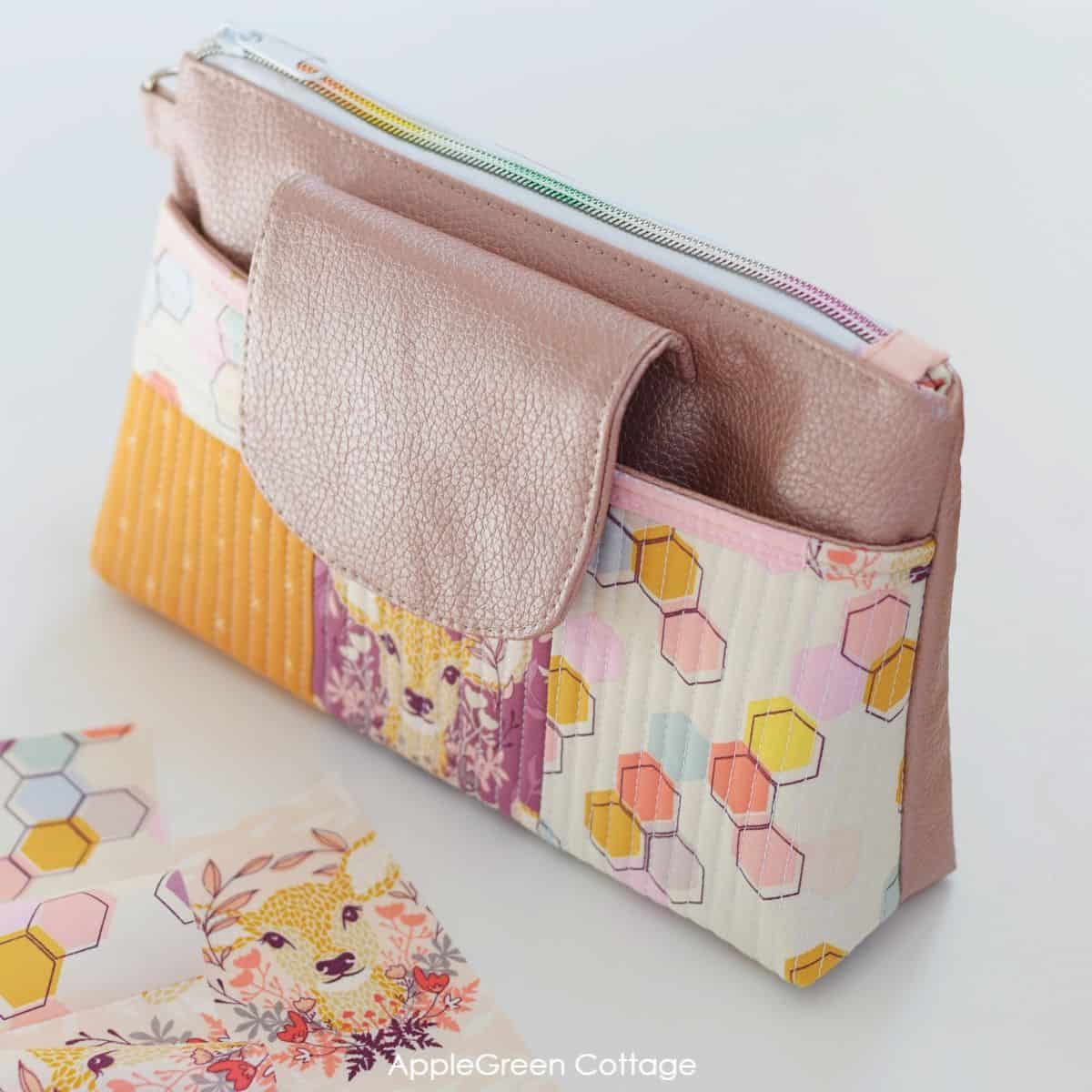 a cosmetic zipper pouch with a front flap, an additional pocket and a removable pouch, in faux leather and quilted fabric.