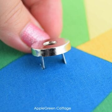 A hand attaching magnetic snaps to fabric, and a second magnetic snap on a bag flap.