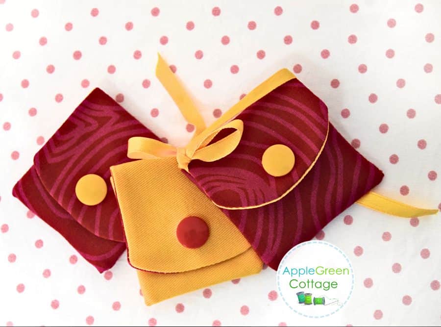 three finished fabric pouches in super small size placed on a polka-dot backed surface