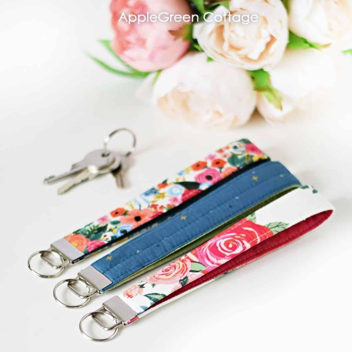 three floral homemade fabric keychains