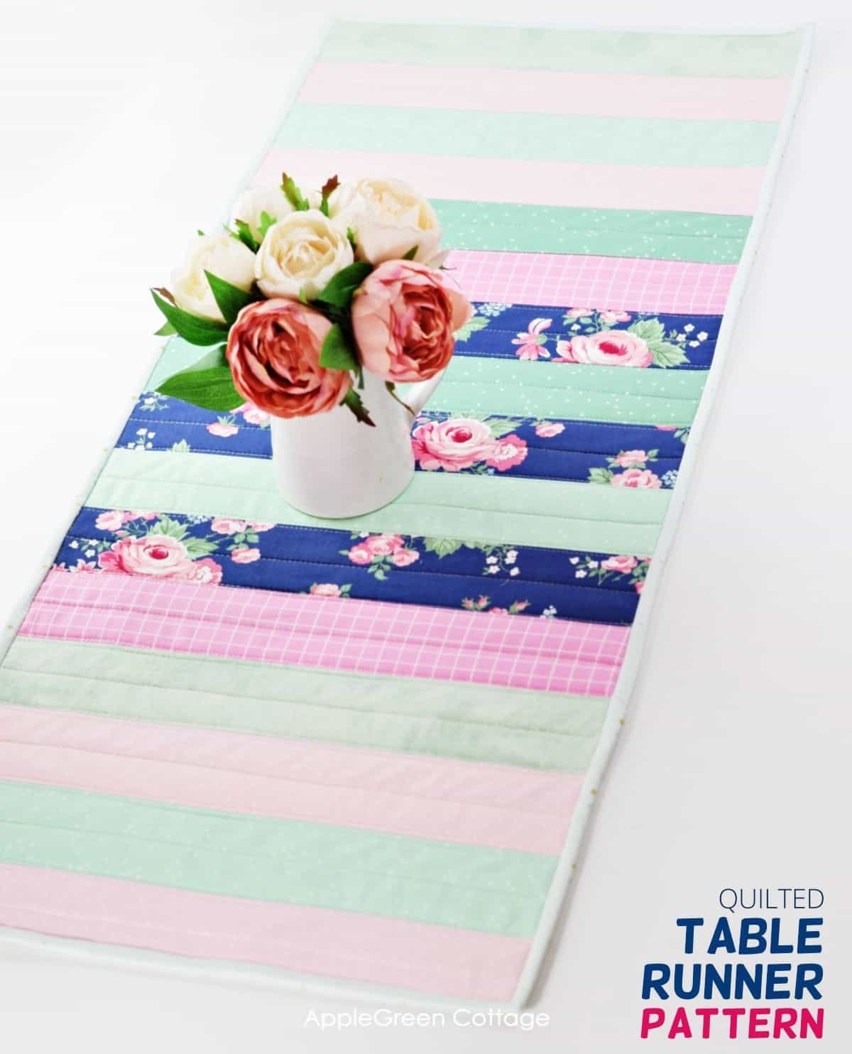 finished quilted table runner on a white surface with flowers