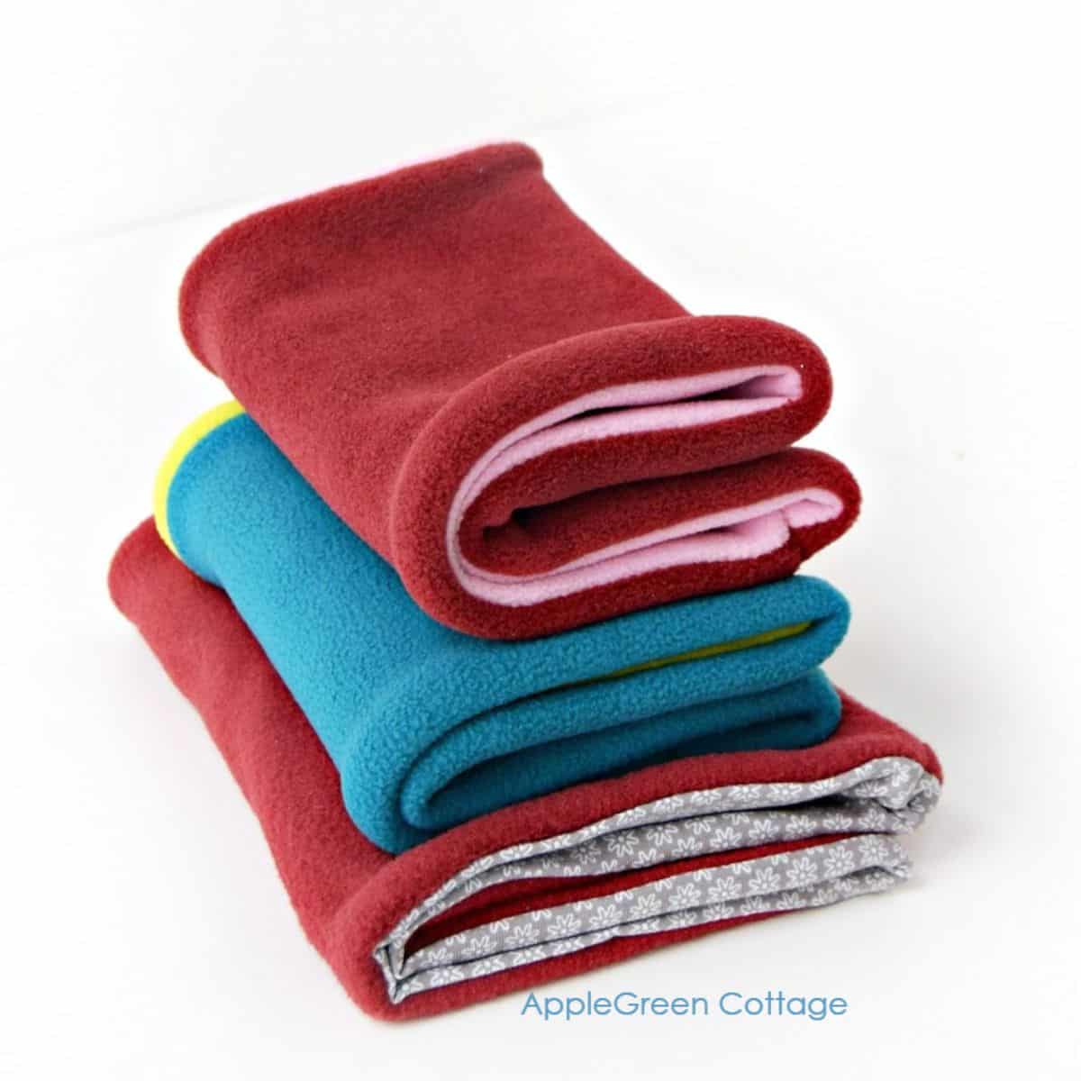 three finished winter cowl scarves sewn with fleece in red and teal
